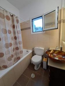 a bathroom with a toilet and a tub and a sink at Villa THEASIS Panoramic in Kastanéa