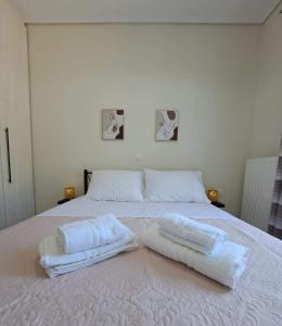 a white bed with two white towels on it at Villa THEASIS Panoramic in Kastanéa