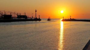 a sunset over a body of water with a boat at La Mimosa in Porto Garibaldi