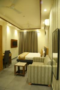 a hotel room with a bed and a couch at Rosewood Grand in Faridabad