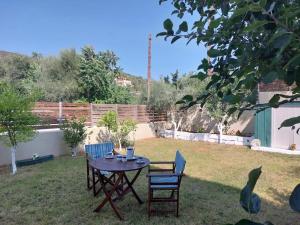 a table and chairs in a yard with a fence at Aurora Studio Lagonissi in Lagonissi