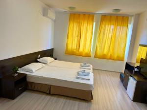 a bedroom with a bed and yellow curtains at Guest Rooms Lina in Kirkovo