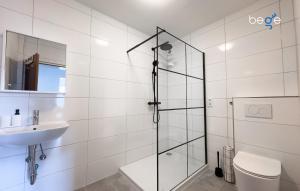 ein Badezimmer mit Dusche, Toilette und Waschbecken in der Unterkunft BEGE APARTMENTS Corporate Lodge in Gelsenkirchen