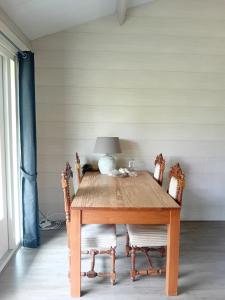 a wooden table with chairs and a lamp on it at B&B Stripsein in Wijnjewoude