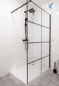eine Dusche mit Glastüren in einem Badezimmer in der Unterkunft BEGE APARTMENTS Corporate Lodge in Gelsenkirchen