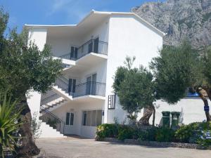 a white building with trees in front of it at Vila Neve 87 Apartman in Veliko Brdo