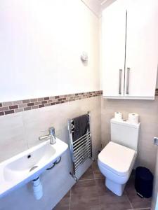 a bathroom with a white toilet and a sink at Enjoy A Spacious 3 Br Home in Gateshead
