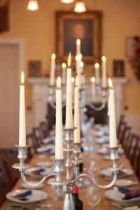 a long table with white candles on top of it at Idyllic 12 bedroom Country Home in Forres
