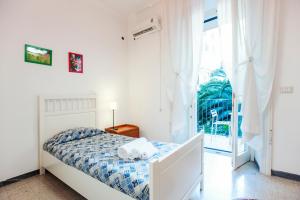 a white bedroom with a bed and a window at Palestrina in Rome