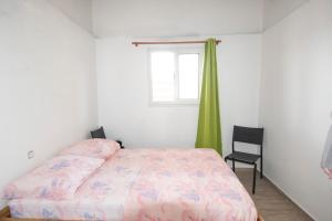 a bedroom with a bed and a window and a chair at Bethanie in Le Gosier