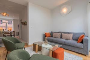 a living room with a couch and chairs and a table at Maison 4 chambres et 2 SDB, avec jardin in Lambersart