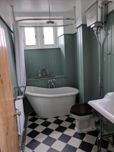 a bathroom with a tub and a toilet and a sink at Large Manor House near Bath in Trowbridge