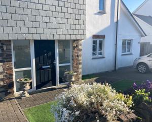 a house with a car parked in front of it at Cosy 1 bed apartment near Crantock beach in Crantock