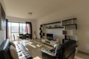 a living room with a couch and a glass table at Spacious Ensuite Bedroom - Gzira in Il-Gżira