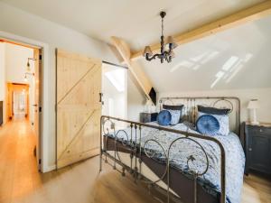 a bedroom with a metal bed with blue pillows at Vakantiehuis Bonne Home in Bree