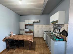 a small kitchen with a wooden table in it at Discovery Hostel in Manaus