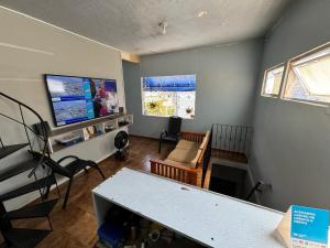 马瑙斯Discovery Hostel的带桌子和电视的客厅