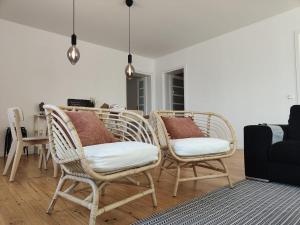 two wicker chairs and a table in a living room at Casa Amarela in Cortegaça