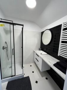 a bathroom with a shower and a sink and a mirror at Apartament Franciszkańska 3 in Tarnów