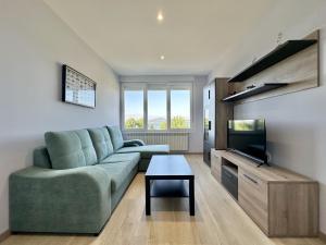 Una sala de estar con un sofá y un televisor de pantalla plana. en Front Beach I, en Sada