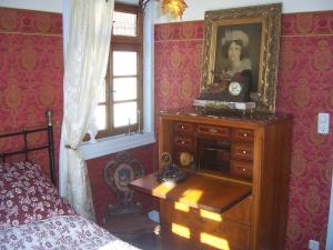 una camera da letto con un comò con un ritratto di una donna sopra di Roter Löwe a Heiligkreuzsteinach
