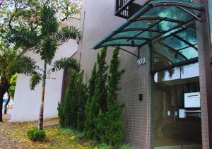 a building with a palm tree in front of it at Gontijo Apart Hotel in Itajubá