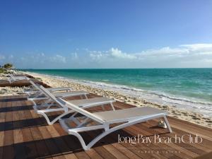 a row of lounge chairs on the beach at Long Bay Beach Club in Long Bay Hills