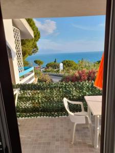 a balcony with a table and chairs and the ocean at Il Faro in Scalea