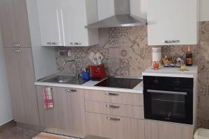 a kitchen with white cabinets and a stove top oven at Il Faro in Scalea