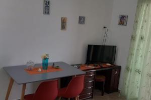 a desk with two red chairs and a table with a television at Il Faro in Scalea