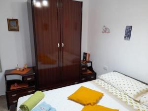 a bedroom with a bed and a cabinet with yellow pillows at Il Faro in Scalea