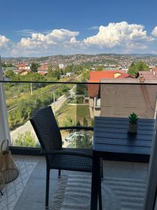 a blue table and chairs on a balcony with a view at ZORA apartmani Sarajevo in Sarajevo