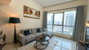 Wonderful 1BR Apt with Marina view في دبي: غرفة معيشة مع أريكة ونافذة كبيرة