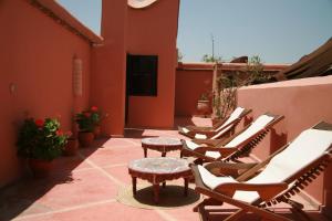 - un ensemble de chaises et de tables sur une terrasse dans l'établissement Dar Soukaina, à Marrakech