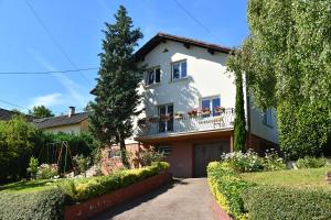 a white house with flowers on the balcony at Gîte les Rosiers du Blosen in Thann