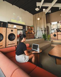 a woman sitting on a couch with a laptop at Sauvage in Quiberon