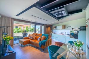 a living room with an orange couch and a kitchen at Doca Seca & Casca de Uva in Porto Moniz