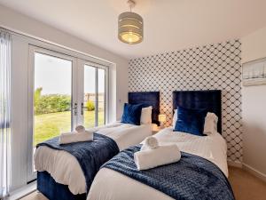 deux lits dans une chambre avec une fenêtre dans l'établissement 4 Bed in Westward Ho 94726, à Westward Ho