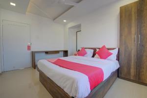 YerandwaneSuper Hotel O RK's Regency Near Navale Hospital Back Gate的卧室里有一张大床，配有红白相间的枕头