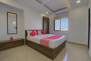 YerandwaneSuper Hotel O RK's Regency Near Navale Hospital Back Gate的卧室里有一张大床，配有红色枕头