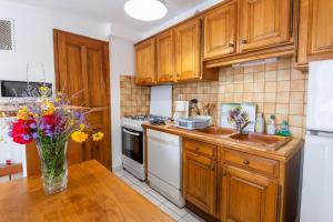 a kitchen with wooden cabinets and a vase of flowers on a table at Gîte Gîtes de France 3/4 personnes à Malbosc in Malbosc