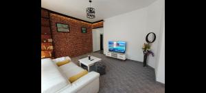 Una sala de estar con un sofá blanco y un televisor. en Apartament ultracentral, en Oradea