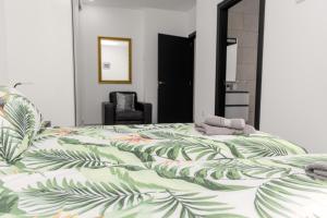 1 dormitorio con 1 cama con colcha verde estampada en Casa Vista Bermeja, en Tinajo