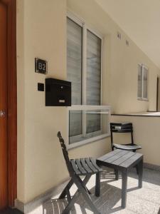 a bench and a table in front of a window at Bella Qawra Maisonette in St. Paul's Bay