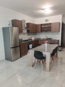 a kitchen with a table and a stainless steel refrigerator at Bella Qawra Maisonette in St. Paul's Bay