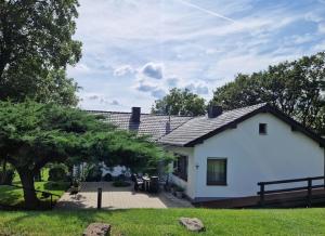 a white house with a patio and a tree at Ferienwohnung Grüne Auszeit in Nideggen