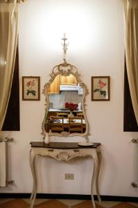 a dressing table with a mirror on a wall at Floreal House - Classic style apartment in Rovigo