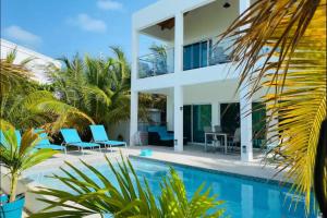 a villa with a swimming pool and a house at Modern villas at Grace Bay, Turks and Caicos Islands in Long Bay Hills