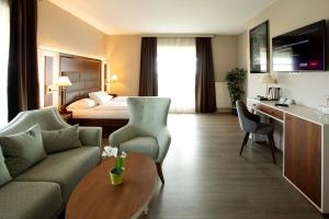 a hotel room with a couch and a table at City Hotel Frankfurt Bad Vilbel in Bad Vilbel