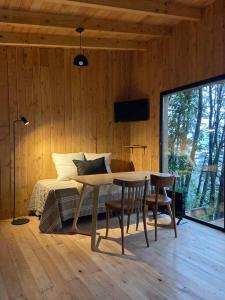 a bedroom with a bed and a table and chairs at Tiny house sobre el lago nahuel huapi in San Carlos de Bariloche